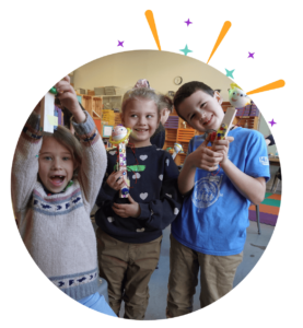 Photo: Three children holding robots they built