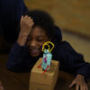 Photo of a child laughing with a robot in front of them
