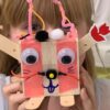 Photo of a child holding a robot they built in front of their face