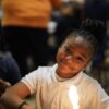 Photo of a child smiling at camera with a robot lit up in front of them
