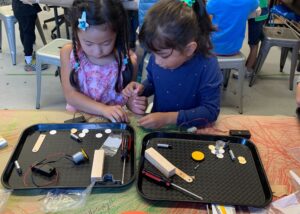 Photo of two students working together building a robot