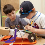 Two students are working hard together on a robot coding project