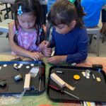 Photo of two students working together building a robot
