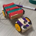 Photo of the SUPERSTAR CAR with a red and green striped back cab and a front cab with purple marker and big googly eyes.  