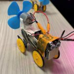 A overhead photo of the proppy jalopy with a blue propeller and yellow tape design and googly eyes. 