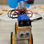 Head-on photo of a proppy jalopy with a smiley face and battery pack on the top side.