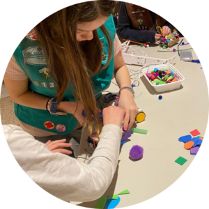 Circular photo of two students building a robot together.