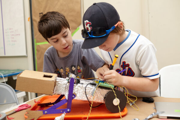 Two students are working hard together on a robot coding project